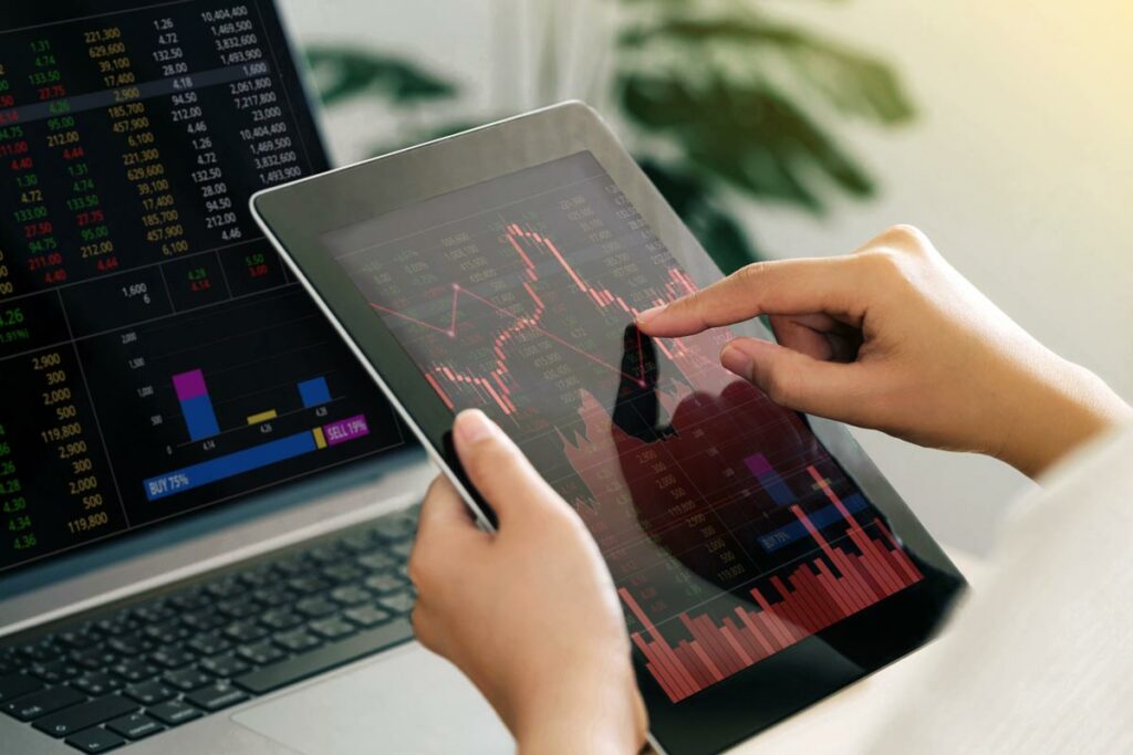 Woman holding tablet showing red, negative-trending stock data
