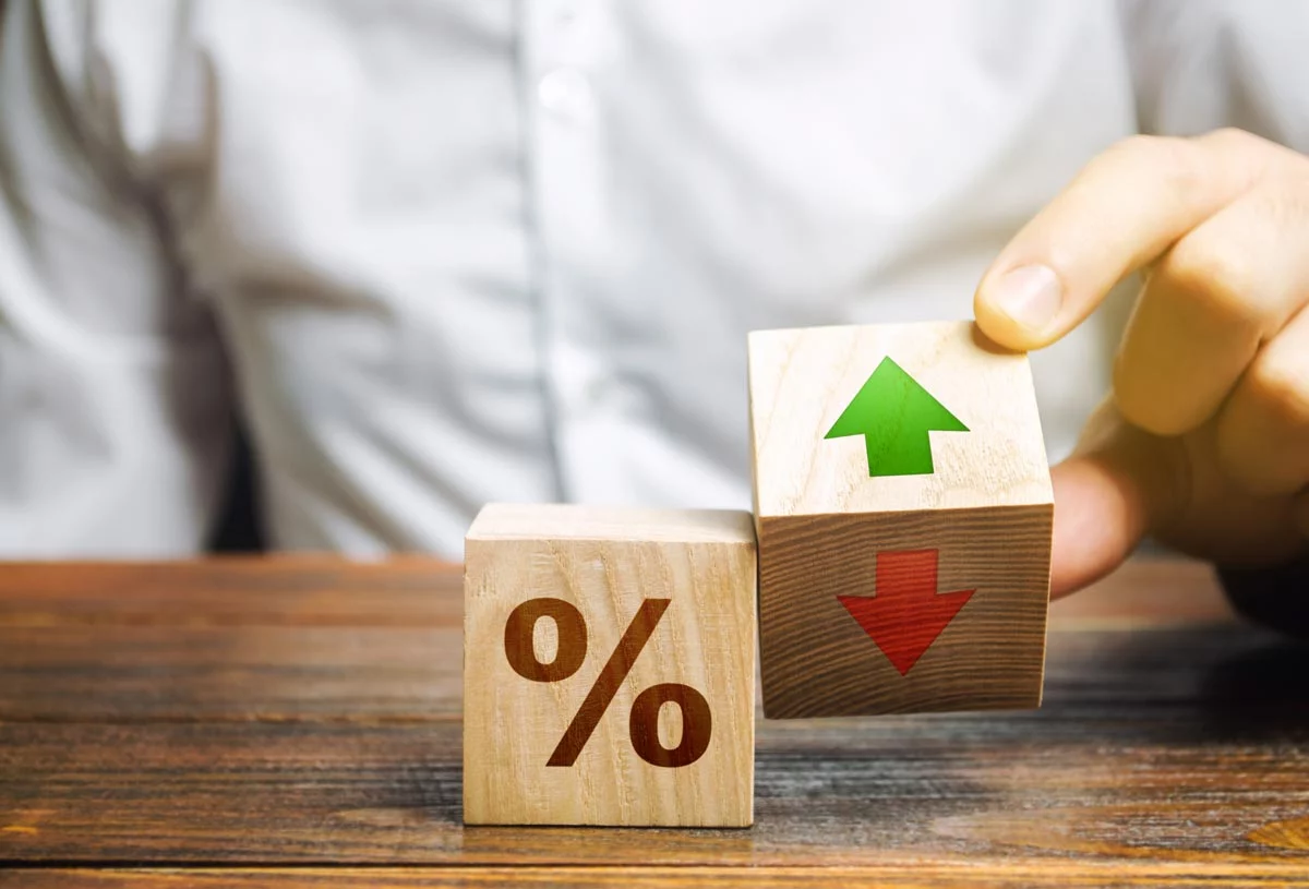 Wooden block with percentage sign and tipping wooden block with green "up" arrow and red "down" arrow