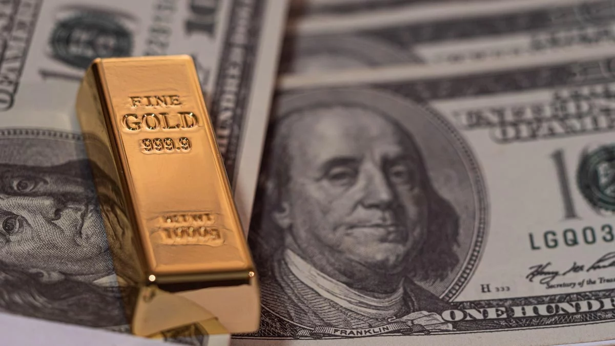 Gold bar over $100 notes