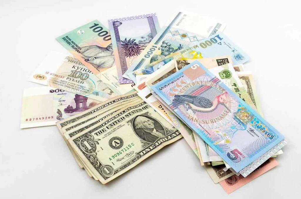 Fan of world currencies around stack of $1 notes