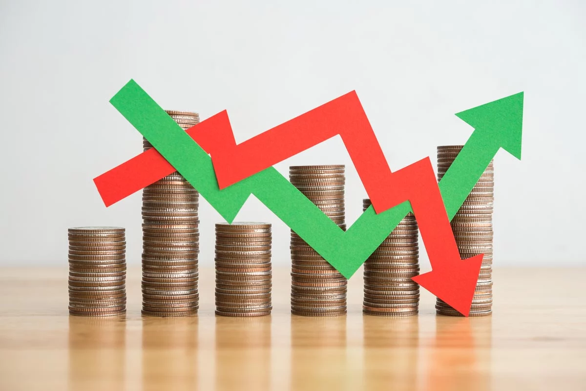 Red and green arrows crisscrossing in front of stacks of coins