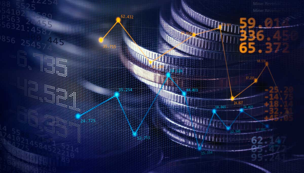 Stacks of coins behind economic data chart