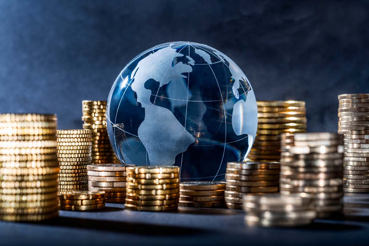 Stacks of gold coins surrounding a globe_1200px Stacks of gold coins surrounding a globe