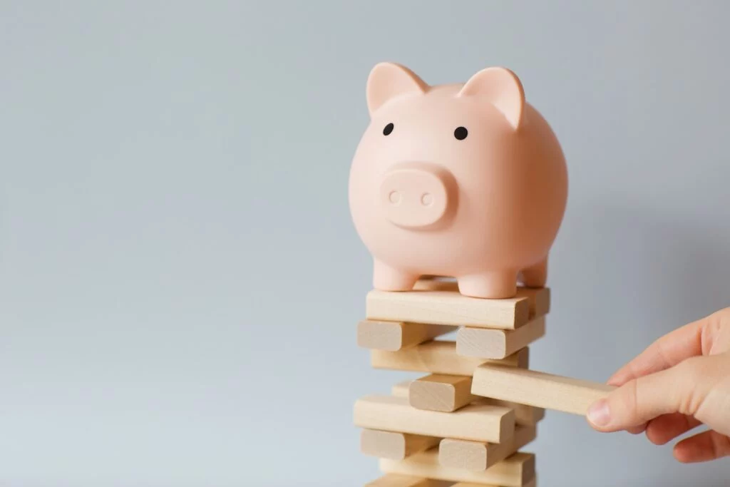 Piggy bank on block stacking game with block being removed