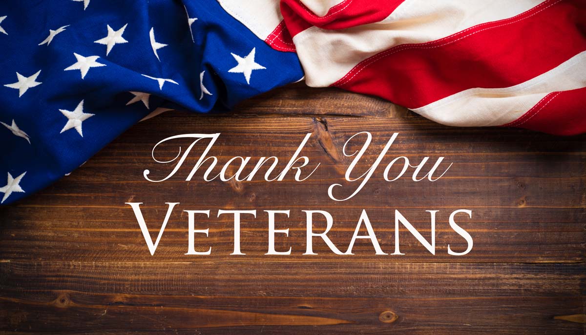 American flag on wooden background with words "Thank You VETERANS"