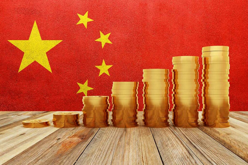 Gold coins stacked before a Chinese flag