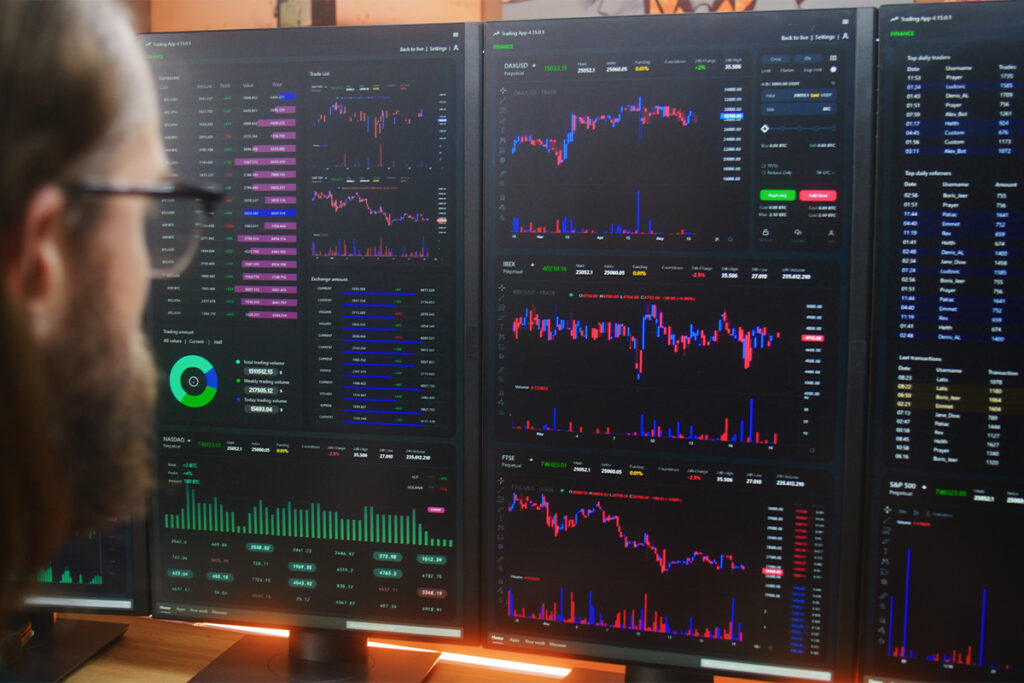 Analyst examining market data on computer monitors