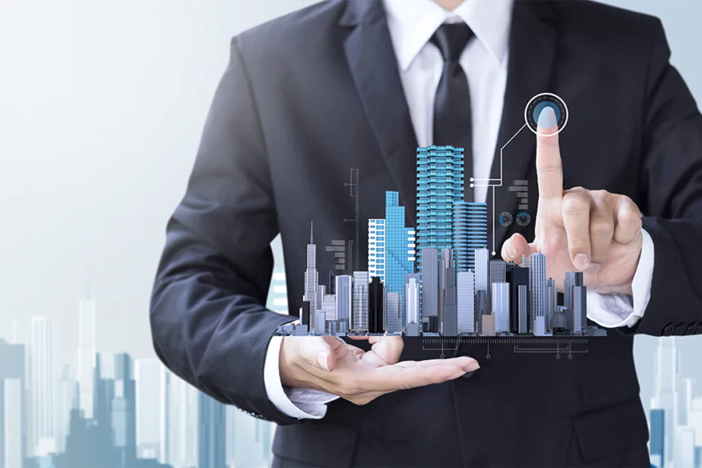 Business man holding up digital image of buildings