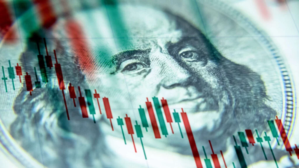 U.S. currency with overlapping declining stock charts.