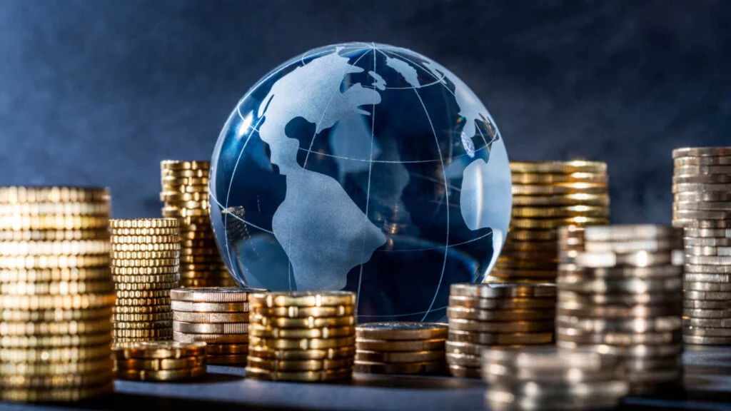 Glass globe surrounded by stacks of coins.