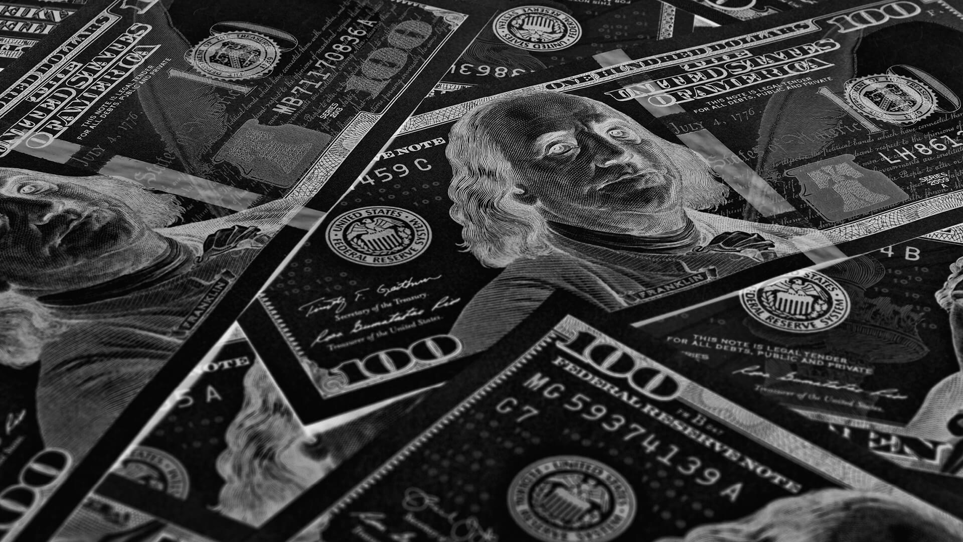 Dark inverted close-up of scattered $100 bills. Dark inverted close-up of scattered $100 bills.
