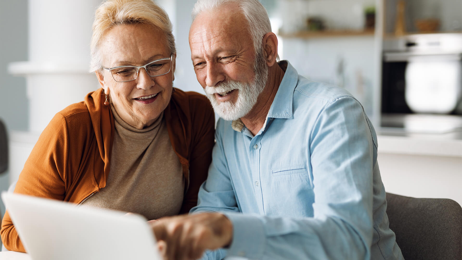 Smiling elderly couple using laptop together