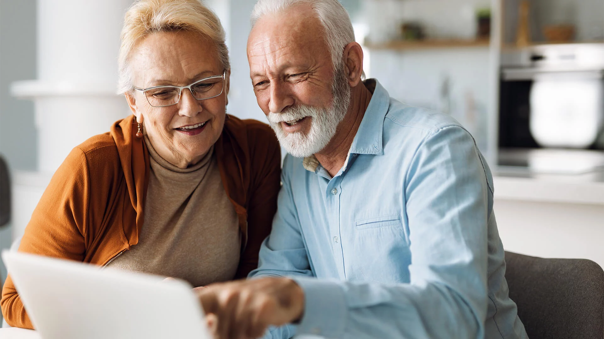 Smiling elderly couple using laptop together