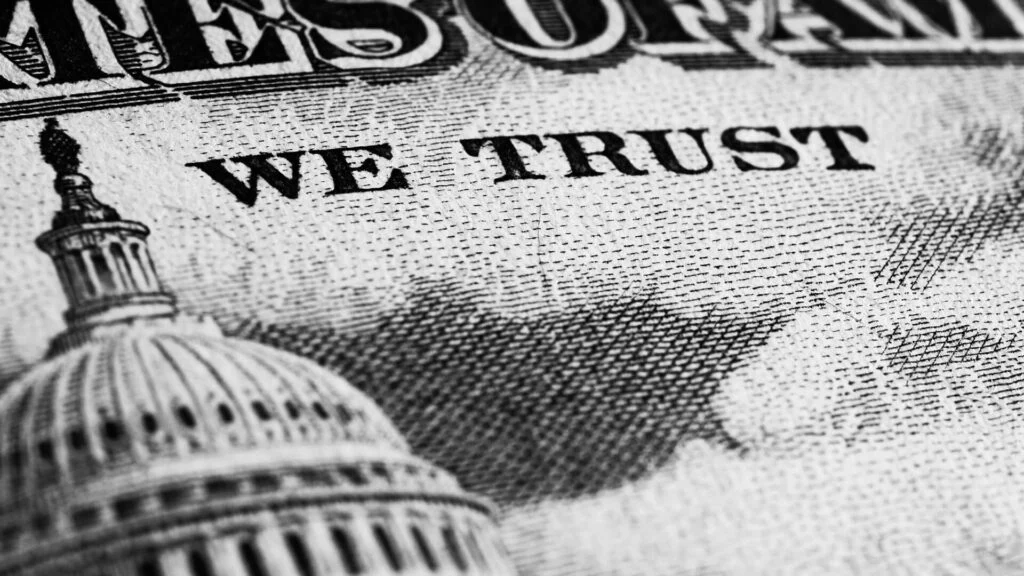 Close-up of money with the U.S. Capitol and text 'WE TRUST' visible.