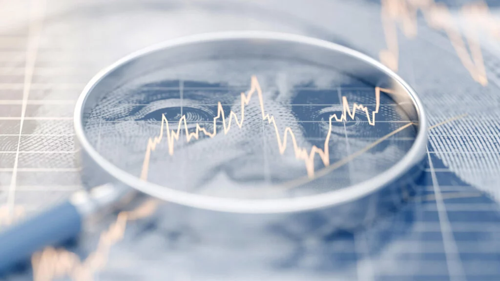 Magnifying glass over dollar bill with graph