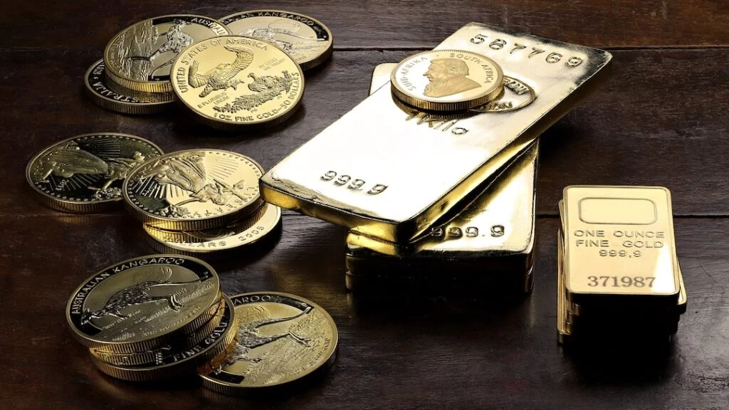Gold coins and bars on wooden surface.